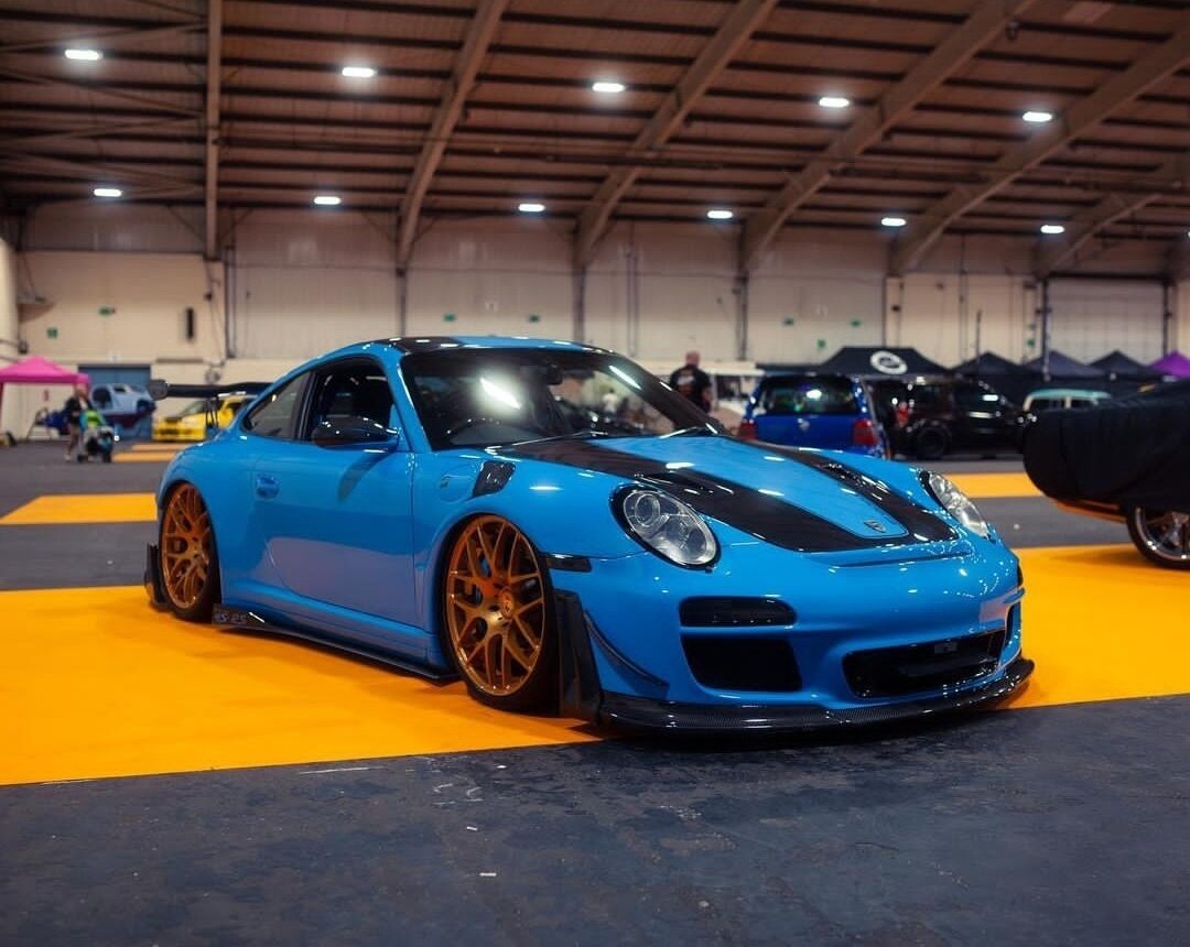 A Blue Porsche in a warehouse.