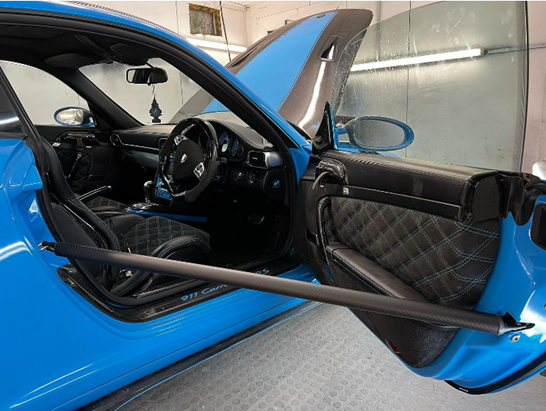 A blue Porsche with the door open on the drivers side.