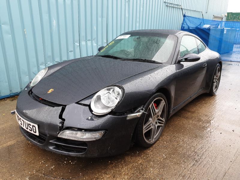 A damaged black Porsche 911 from the front.