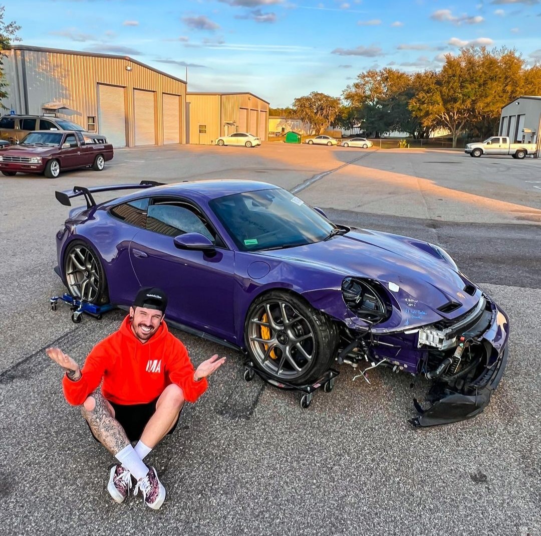 Mat Armstrong sits next to his damaged purple Porsche 992 GT3.