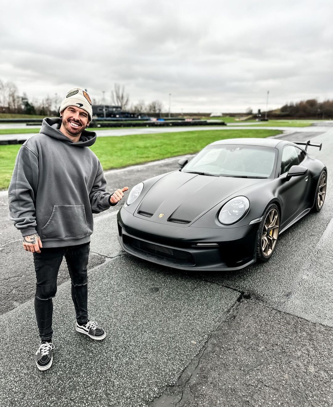 Mat Armstrong stands next to the fixed Black Porsche 992 GT3.