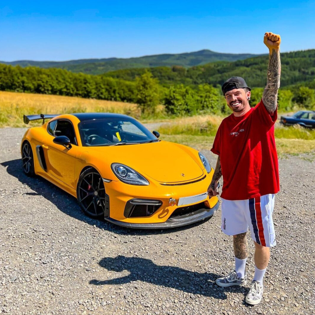 Mat Armstrong standing next to his Yellow Cayman S.