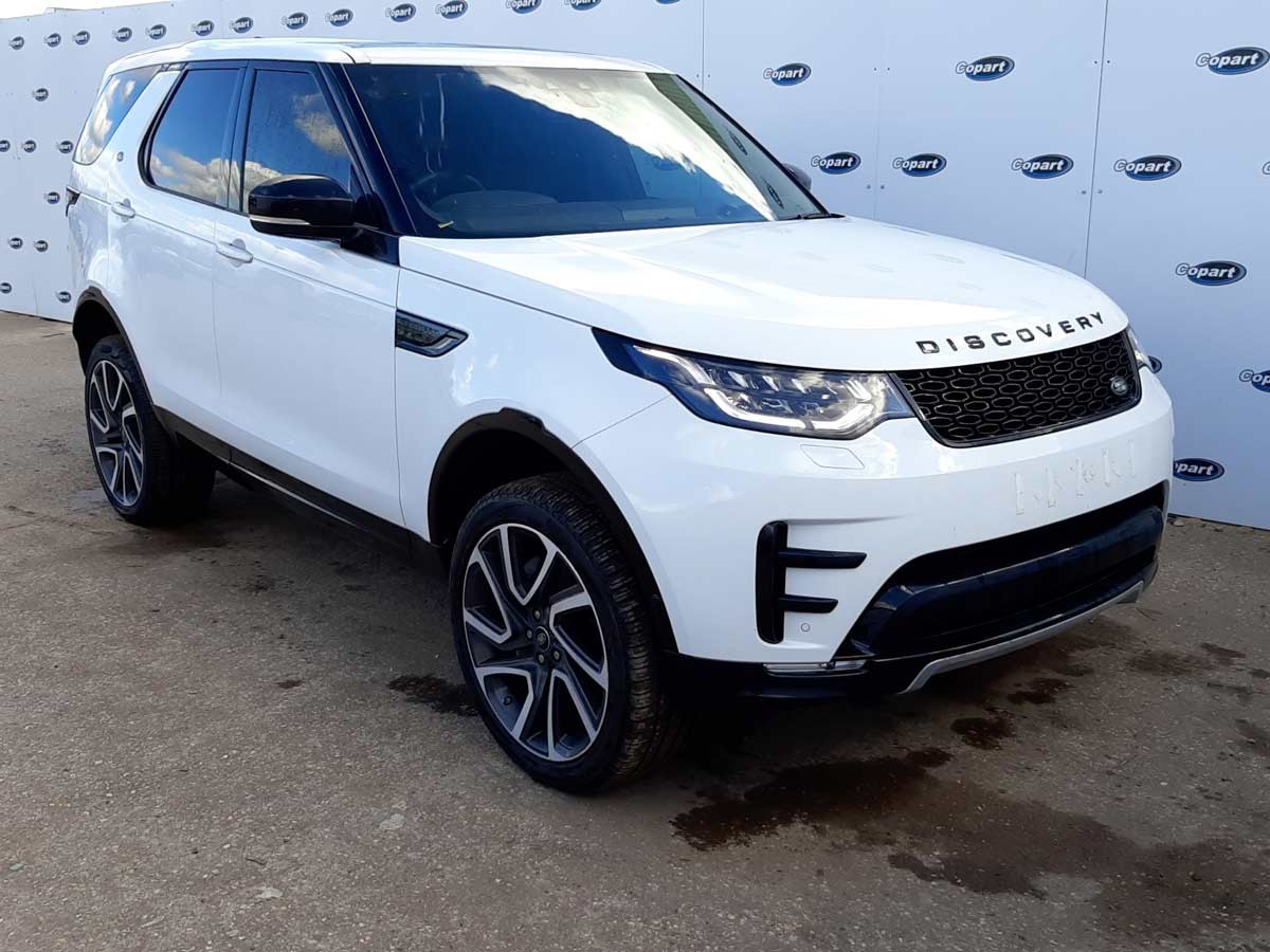 “A white Land Rover Discovery parked in a Copart lot”