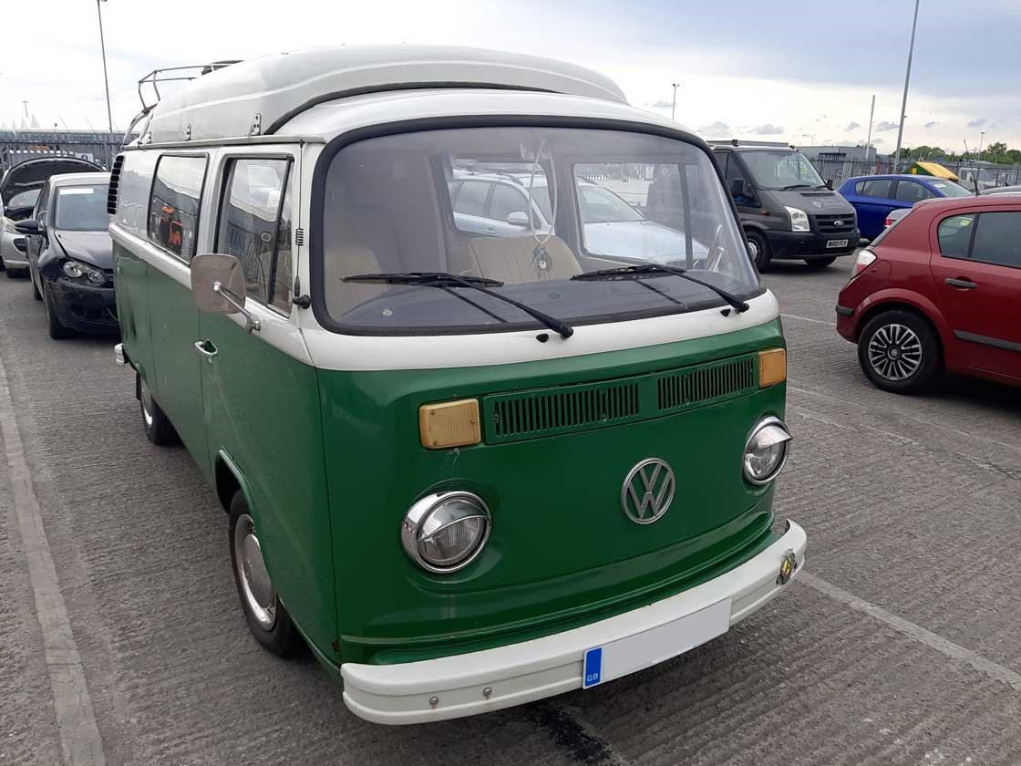 A green Volkswagen Transporter parked at a Copart site.